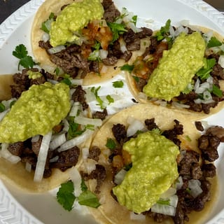 Carne Asada Taco — 2 oz cooked asada; 2 tortillas; 1 tbsp guacamole